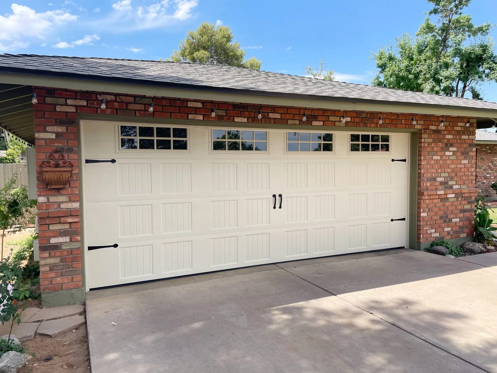 Cream carriage-house garage door with windows on a brick Valley home, installed by Morning Star